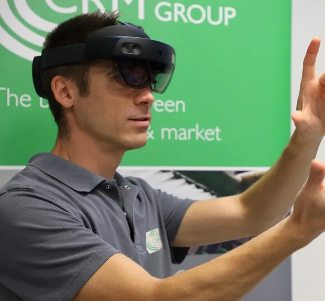 Operator wearing a HoloLens 2 headset while following holographic work instructions at a machine