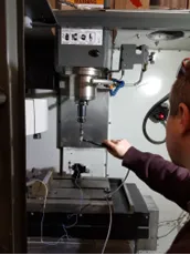 Man measuring a CNC milling machine